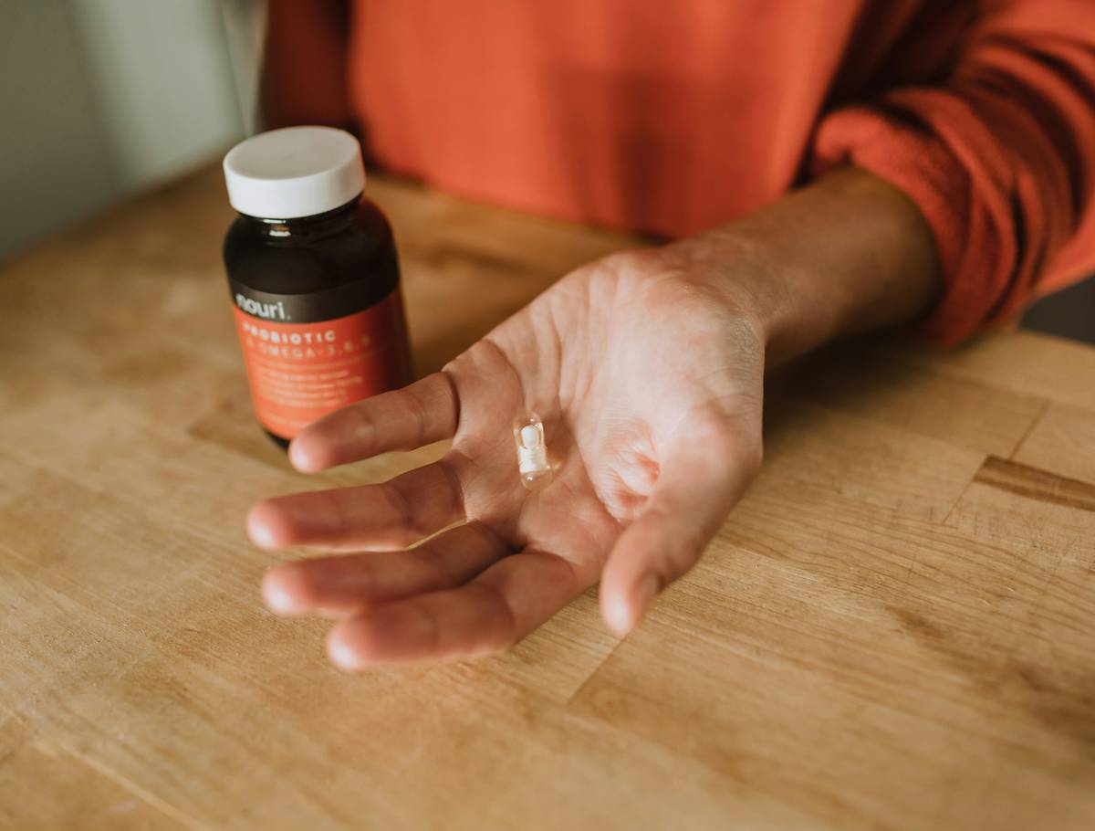 men over 40 vitamins recommended: middle-aged man reviewing supplement bottles at kitchen table